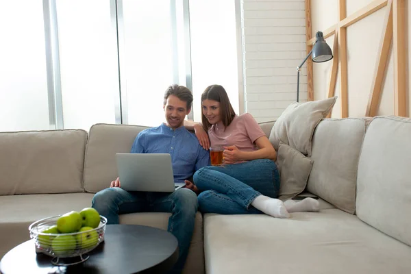 Мужчина и женщина учатся дистанционно в гостиной — стоковое фото