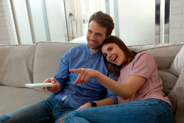 Laki-laki dan perempuan menonton TV dan duduk di sofa — Stok Foto