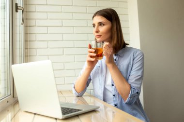 Güzel bayan masada çay içmekten zevk alıyor.