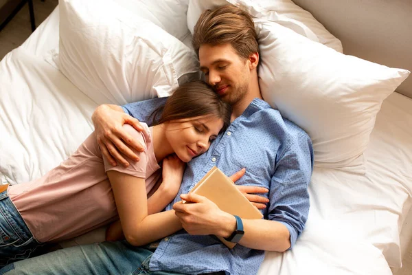 Молода пара в любові обіймає один одного в ліжку — стокове фото