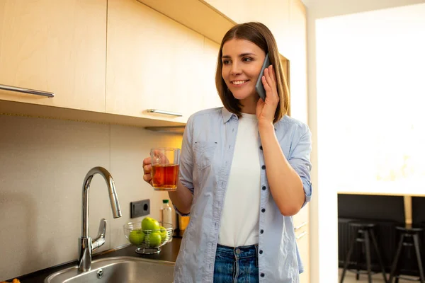 Joven mujer hablando por teléfono inteligente en casa — Foto de Stock