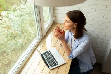 Genç ve güzel bir kadın pencereye bakıyor.