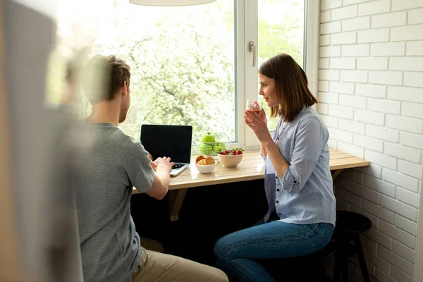 Man arbetar på laptop och kvinna njuter av te — Stockfoto