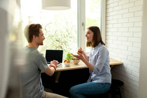 Férfiak és nők beszélgetnek és ülnek az asztalnál — Stock Fotó