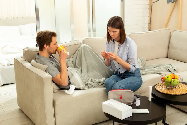 Liebevolles Weibchen pflegt kranken Mann im Zimmer — Stockfoto