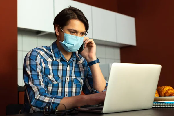 Uomo in maschera sterile con gadget in cucina — Foto Stock