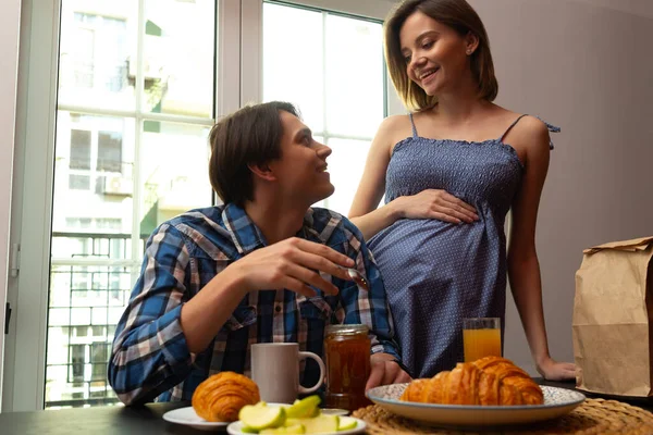 Mujer embarazada feliz preparando las comidas para el marido —  Fotos de Stock