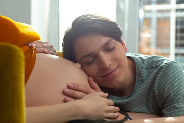 Calma masculino chegando mais perto de seu futuro filho e sorrindo — Fotografia de Stock