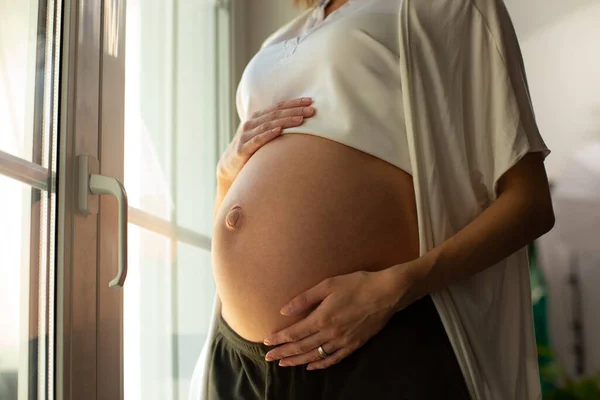 Hermoso vientre de la mujer embarazada con sus manos tocándolo — Foto de Stock