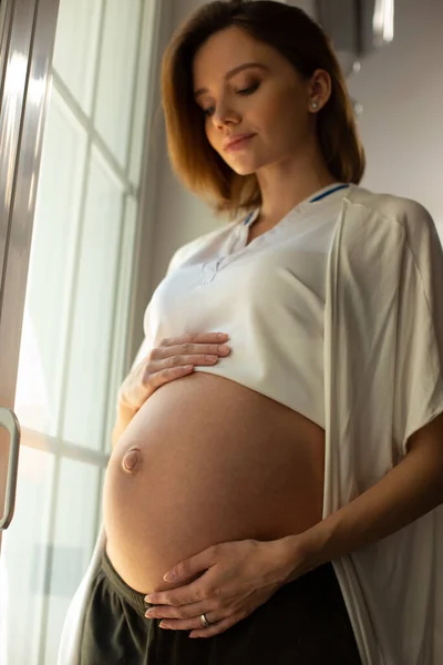 Békés fiatal hölgy várja a baba születését. — Stock Fotó