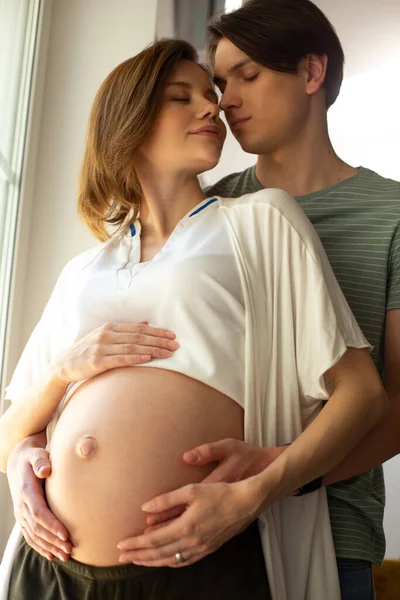 Casal romântico esperando bebê de pé com os olhos fechados — Fotografia de Stock