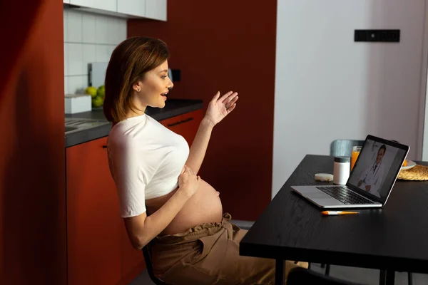 Barátságos terhes nő, amelynek kellemes online találkozó orvos — Stock Fotó
