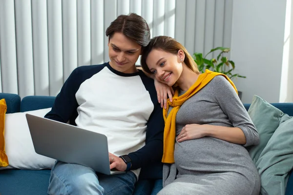 Мирная молодая пара смотрит на экран ноутбука и улыбается — стоковое фото