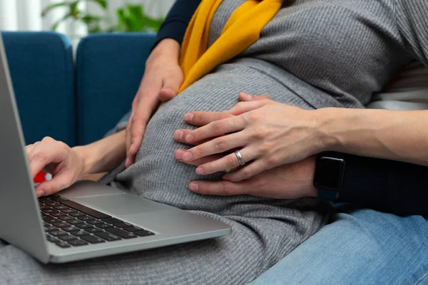 Schwangerschaft eines jungen Paares und modernes Gadget auf dem Schoß — Stockfoto
