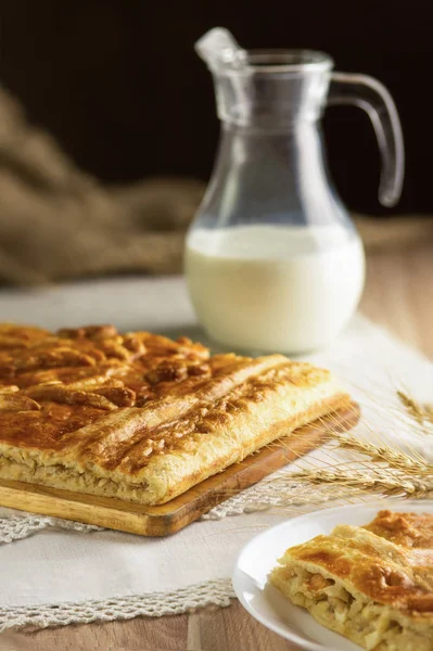 Torta sostenuta e brocca di latte — Foto Stock