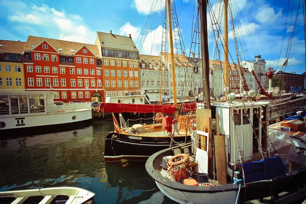 Färgglada hus i Copenhagen gamla stan med båtar och fartyg i kanalen framför dem — Stockfoto