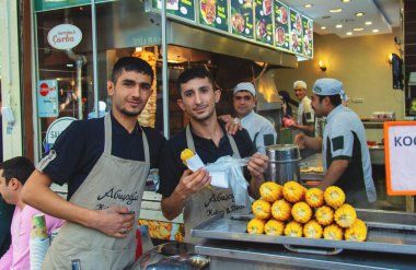 Genç haşlanmış mısır satıcısı, popüler sokak yemekleri