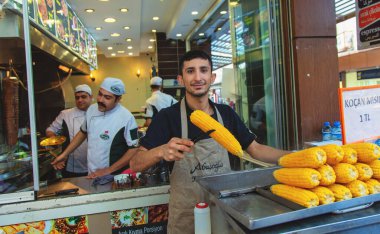 Genç haşlanmış mısır satıcısı, popüler sokak yemekleri