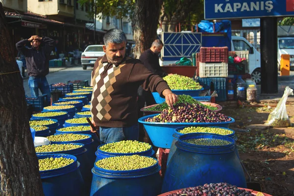 Vendeur d'olives vertes crues de nouvelle récolte sur un stand de marché — Photo