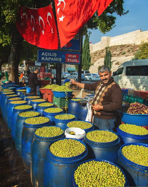 Продавец зеленых оливок нового урожая на рынке — стоковое фото