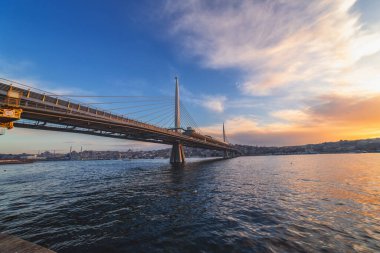 İstanbul 'da gün batımı ve Golden Horn ve Halic metro köprüsü manzarası