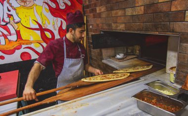 Fırın şefi Türk pizzası ya da lahmacun yapıyor.