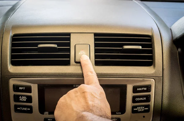 Finger hitting car emergency light botton