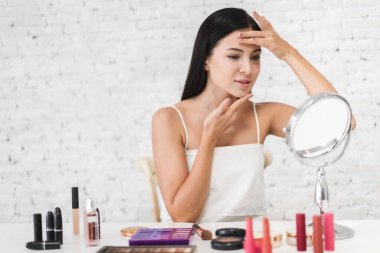 Gülümseyen genç güzel kadın taze sağlıklı cilt mirr bakıyor