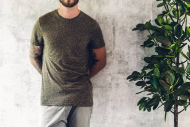 Duvar arka planda boş tişörtlü kas genç adam. Gömlek des