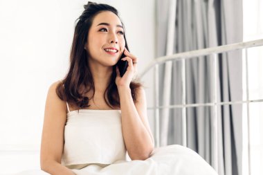 Mutlu kadın evde yatakta tablet bilgisayar kullanarak rahatlatıcı.te