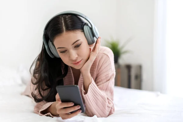 Hermosa joven mujer relajante escuchando música con auriculares —  Fotos de Stock