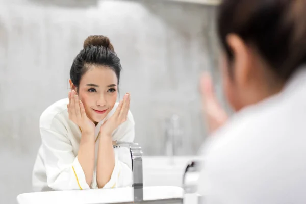 Mooie jonge Aziatische vrouw wassen schoon gezicht met water en SM — Stockfoto