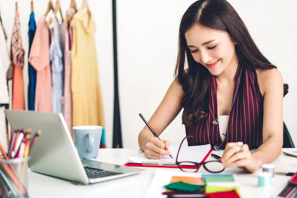 Mujer sonriente asiática diseñadora de moda que trabaja con ordenador portátil — Foto de Stock