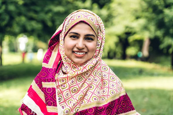 Portrait of happy arabic muslim woman with hijab dress smiling a