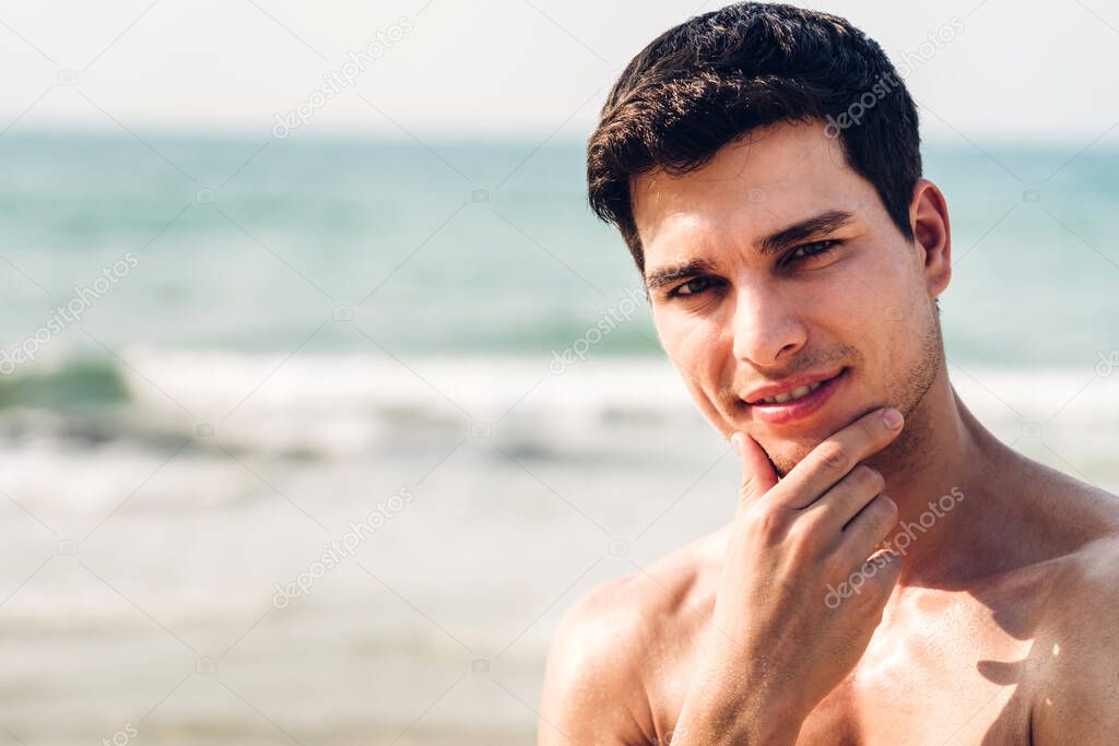 Portrait of smiling handsome sexy man showing muscular fit body 