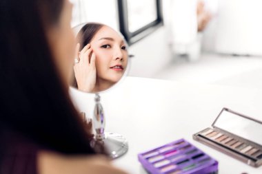 Gülümseyen genç güzel kadın taze sağlıklı cilt mirr bakıyor