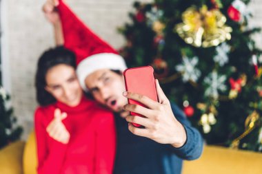 Noel Baba şapkalı romantik çift İsa 'yı dekore ederken eğleniyor.