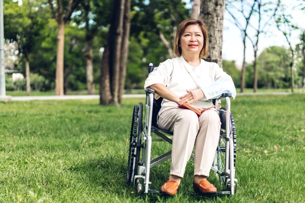 노인 성인 노인 아시아 여성은 휠체어에 앉아 독서 보 — 스톡 사진