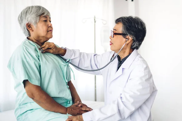 Médico senior femenino que consulta y examina a la paciente senior — Foto de Stock