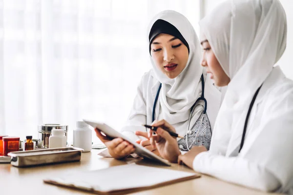 두 명의 이슬람 여성 의사가 클립보드와 태블릿을 가지고 일하고 있다 — 스톡 사진