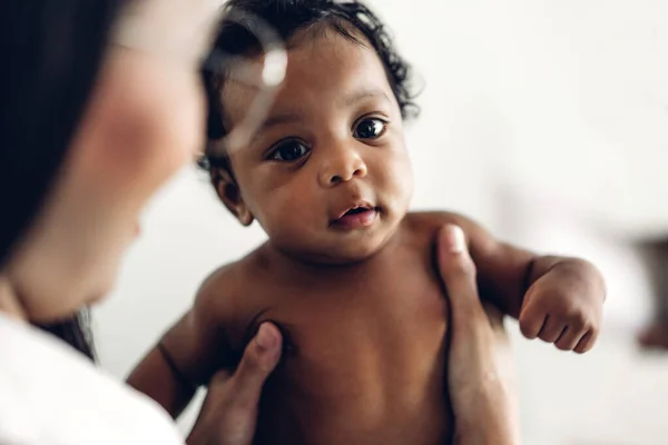 Anya egy aranyos kis afro-amerikai babát tart a karjaiban. — Stock Fotó