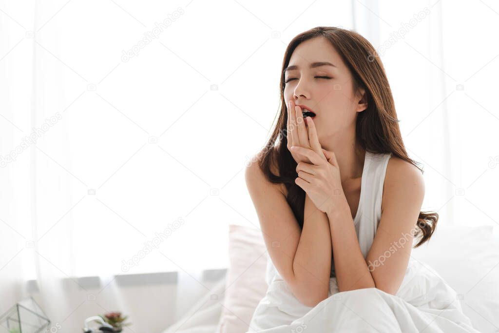 Woman stretching happy and relaxed after wake up in the morning 