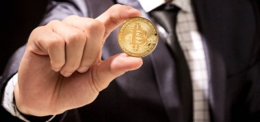 Bitcoin siyah arka planda tutan işadamı