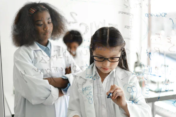 Estudantes adolescentes aprendendo e escrevendo brainstorm na janela de vidro — Fotografia de Stock