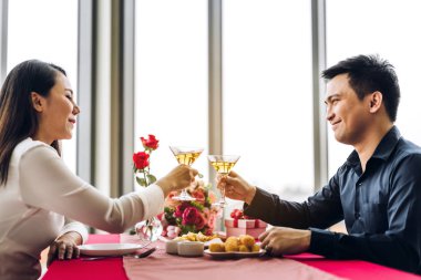 Romantik genç mutlu çift gevşeyip konuşuyor ve şarap içiyor.