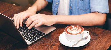 Kadın içme kahve ve kahve dükkanında dizüstü bilgisayarda çalışma