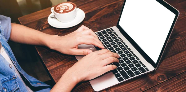 Woman drinking coffee and work on laptop computer at coffee shop