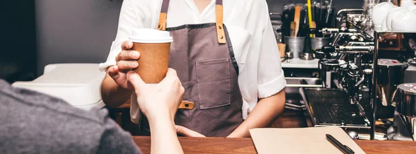 Mujer barista dando taza de café al cliente en la cafetería — Foto de Stock