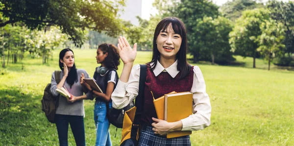 Porträtt av glad leende asiatiska student ler mot kameran viftar — Stockfoto