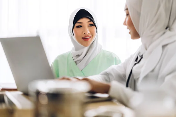 Muslim asian female doctor consulting and check up information o